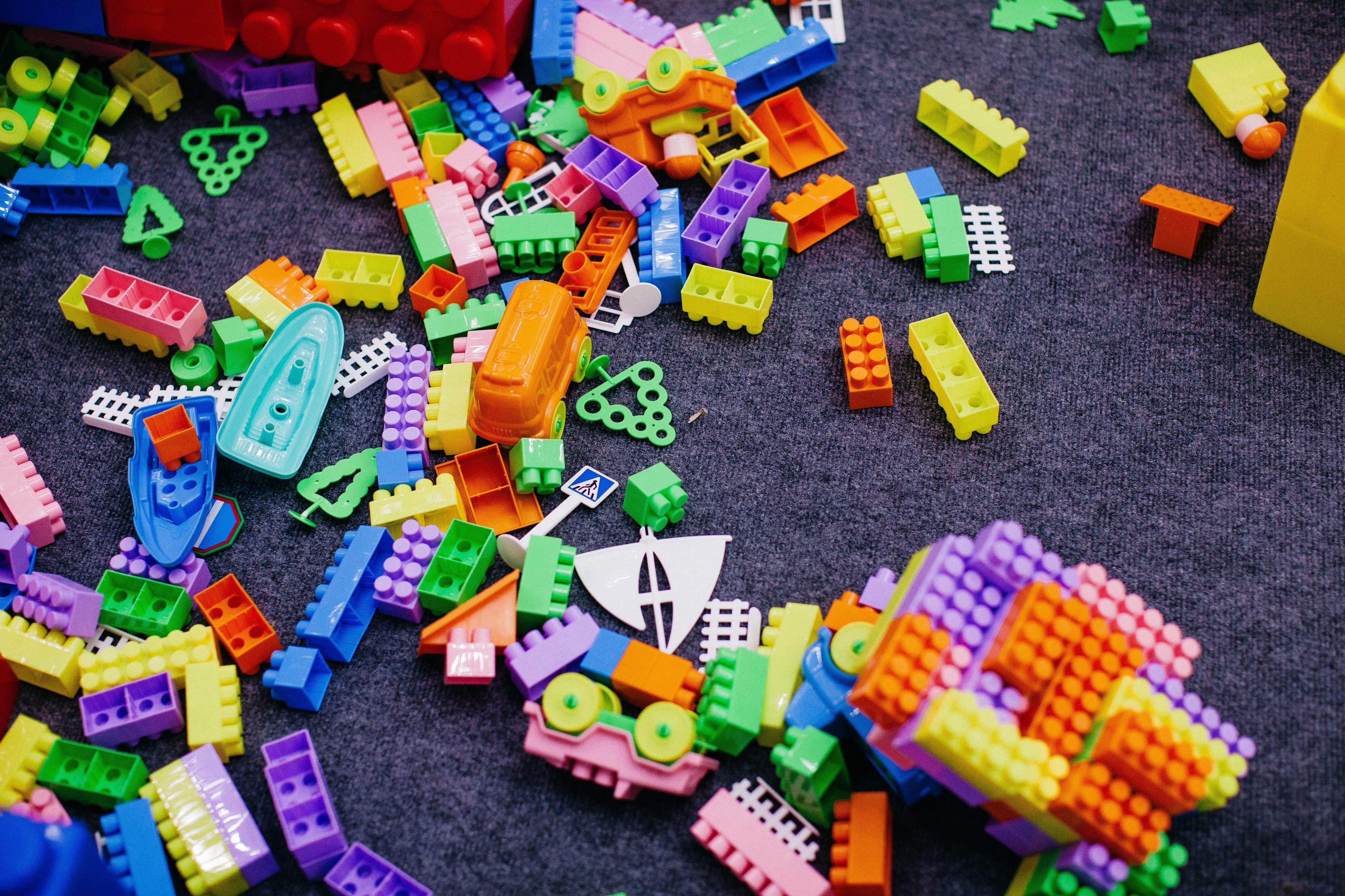 A scattered pile of toys illustrating visual clutter that triggers mom anxiety, sensory overload, and maternal burnout.