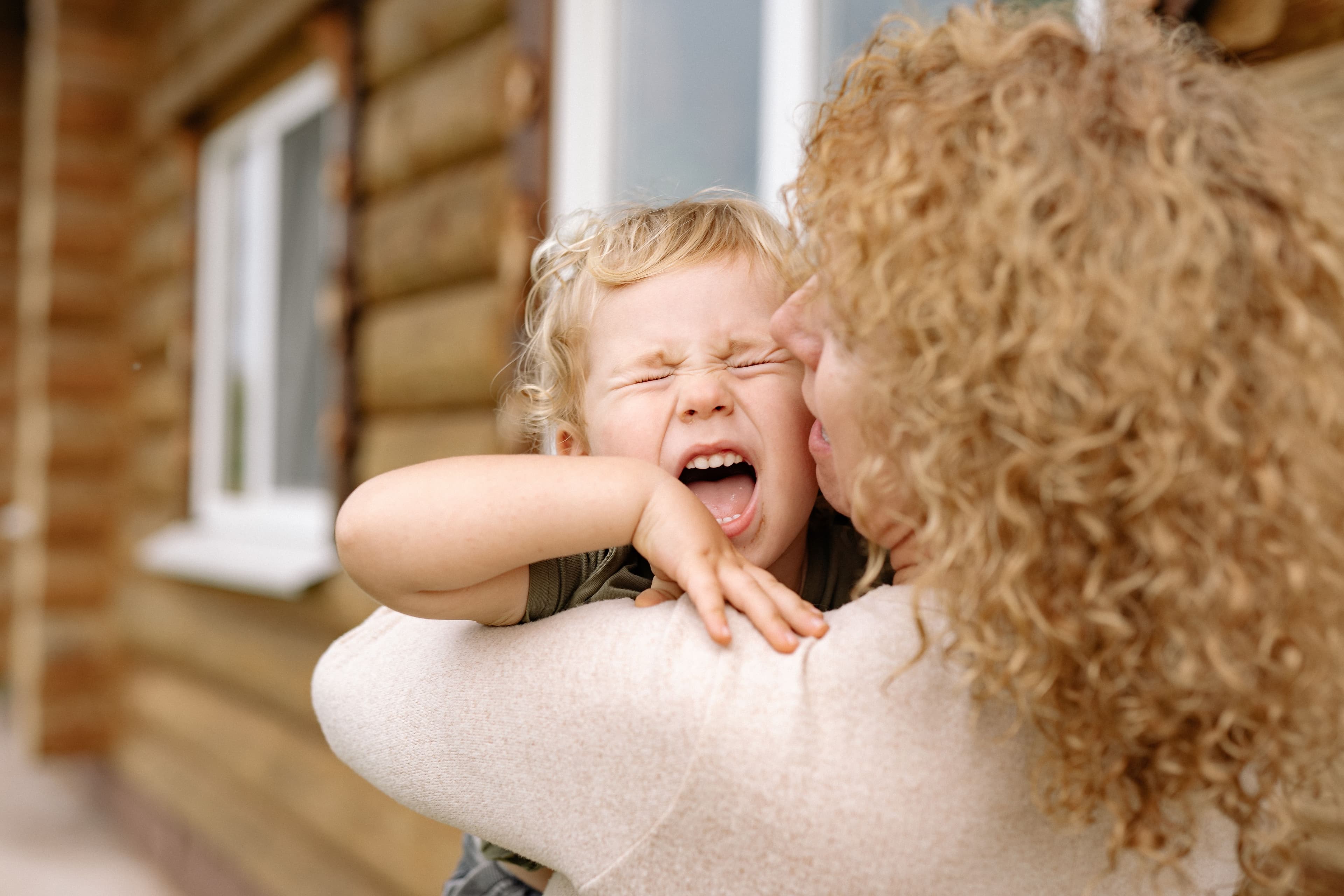 Mother holding a screaming, overstimulated toddler, representing mom rage and emotional self-regulation therapy in Minnesota.