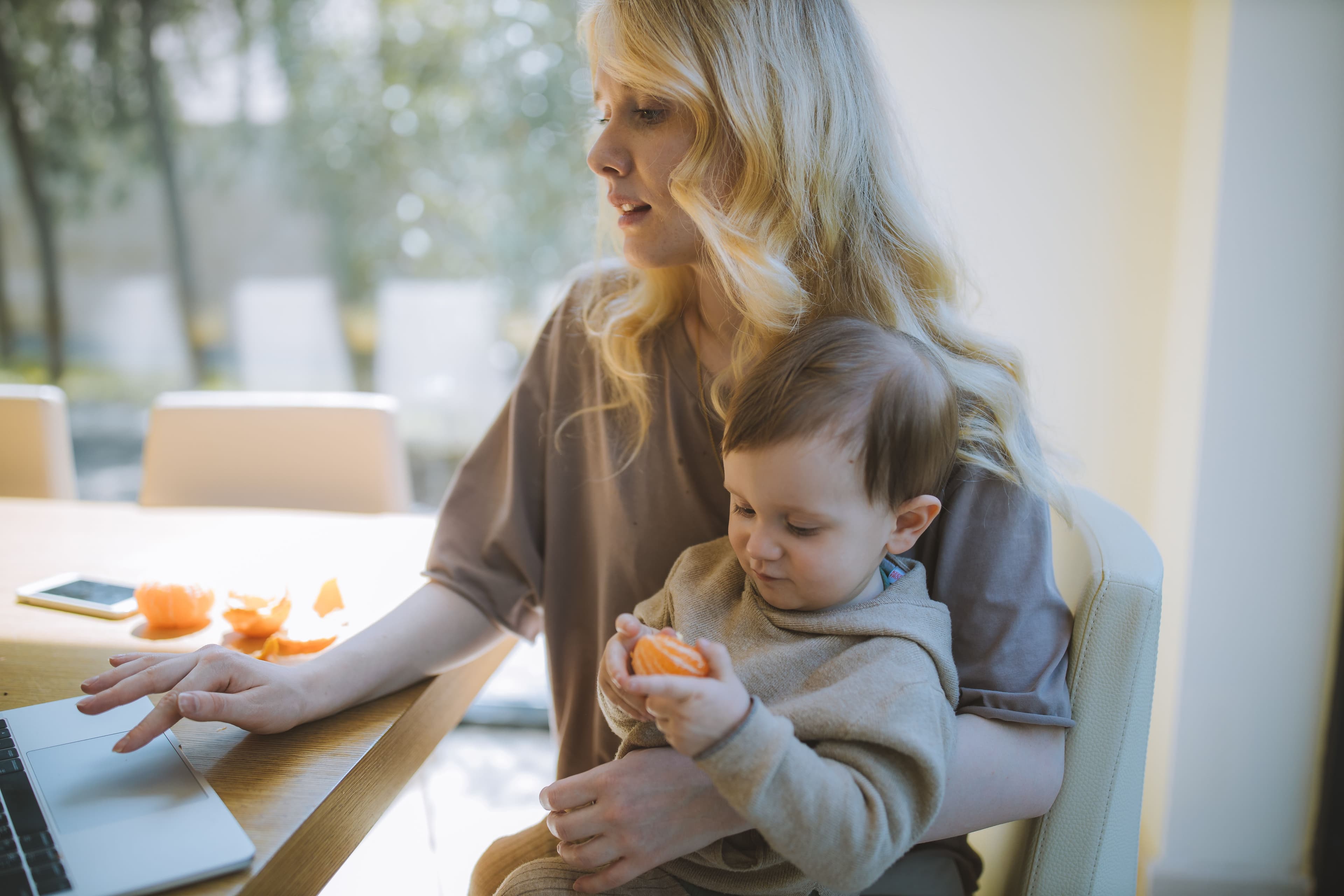 Working mom holding her toddler illustrating the balancing act of career, motherhood, and maternal mental health in Minnesota
